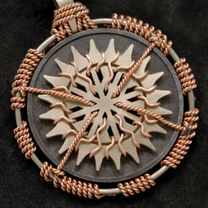 Detail view of 18K Rose Gold and 18K Palladium White Gold and Sterling Silver Sewn Silver Metal Sun pendant featuring 20 pointed gear by Caps Brothers