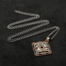 Load image into Gallery viewer, Laying down view of 18K Rose Gold and 18K Palladium White Gold and Sterling Silver and Ruby Sewn Gold Metal Confidence pendant and chain with endless loop necklace featuring 4 pointed gear by Caps Brothers