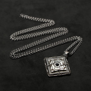 Laying down view of Sterling Silver and 18K Palladium White Gold Accents and Black Sapphire Sewn Silver Metal Confidence pendant and chain with endless loop necklace featuring 4 pointed gear by Caps Brothers