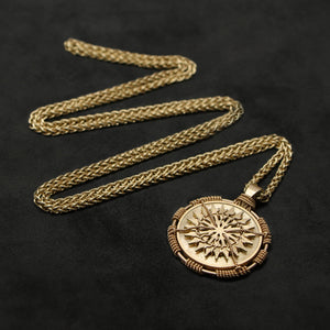 Laying down view of 18K Yellow Gold Sewn Gold Metal Sun pendant and chain with endless loop necklace featuring 20 pointed gear by Caps Brothers