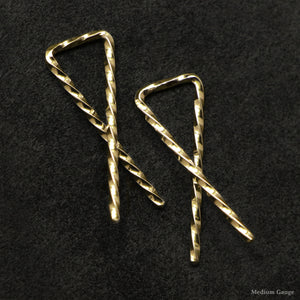 Detail view of 18K Yellow Gold Sibling Ribbons Twisted Earrings representing we are all brothers and sisters by Caps Brothers
