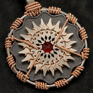 Detail view of 18K Rose Gold and 18K Palladium White Gold and Sterling Silver and Ruby Sewn Gold Metal Majesty pendant featuring 20 pointed gear by Caps Brothers