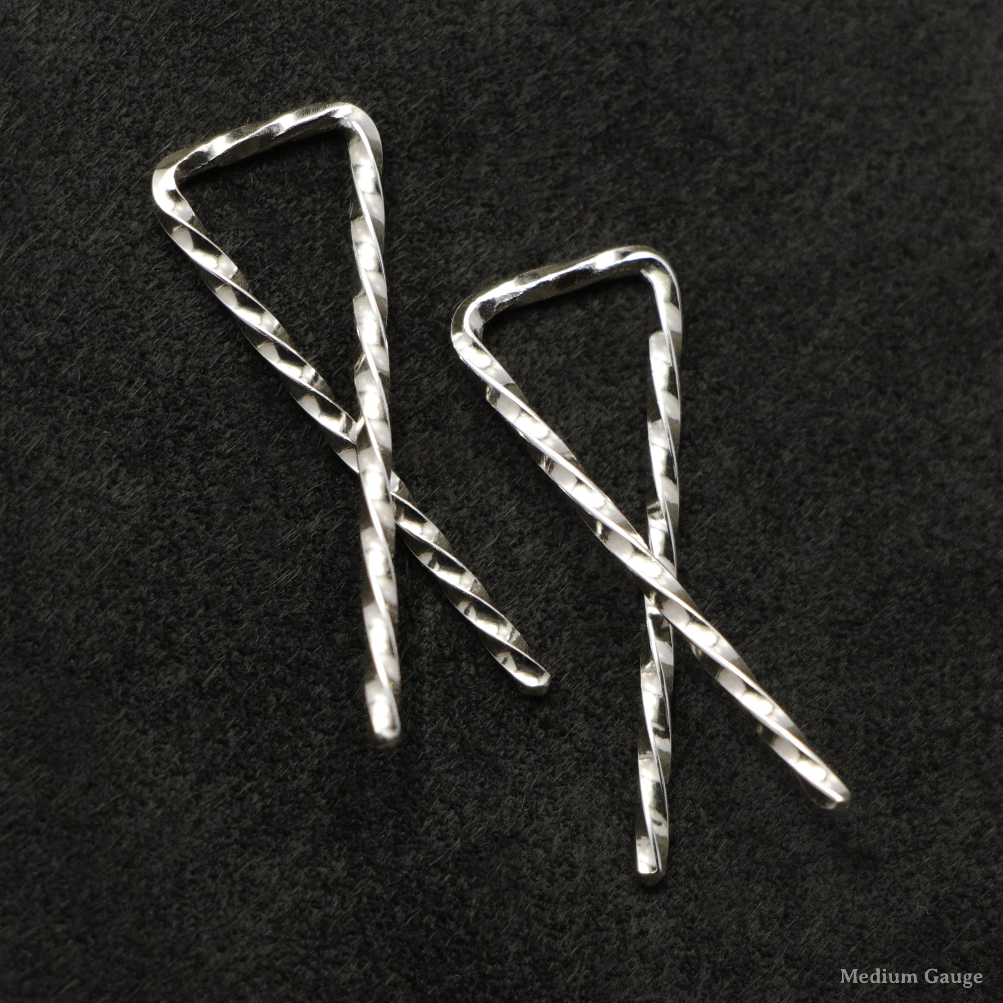 Detail view of Sterling Silver Sibling Ribbons Classic Earrings representing we are all brothers and sisters by Caps Brothers