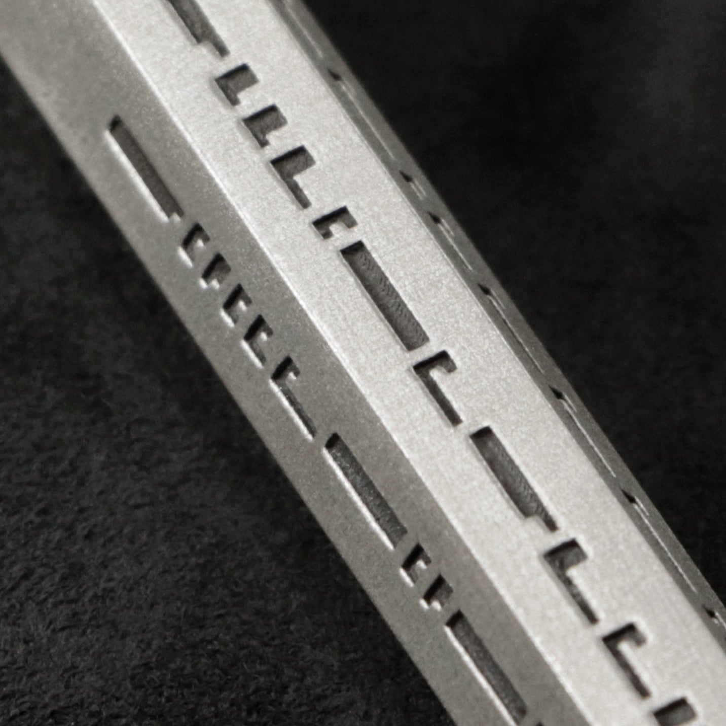 Detail view of Code of Gratitude hexagonal sterling silver pendant and chain with endless loop necklace featuring ASCII Rays Code by Caps Brothers