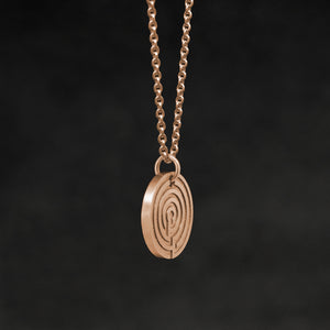Side view of 18K Rose Gold Journey pendant and chain necklace featuring labyrinth as inward journey by Caps Brothers