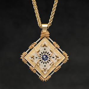 Hanging front view of 18K Yellow Gold and 18K Palladium White Gold and Sapphire Sewn Gold Metal Confidence pendant and chain with endless loop necklace featuring 4 pointed gear by Caps Brothers