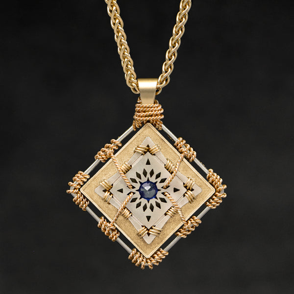 Hanging front view of 18K Yellow Gold and 18K Palladium White Gold and Sapphire Sewn Gold Metal Confidence pendant and chain with endless loop necklace featuring 4 pointed gear by Caps Brothers