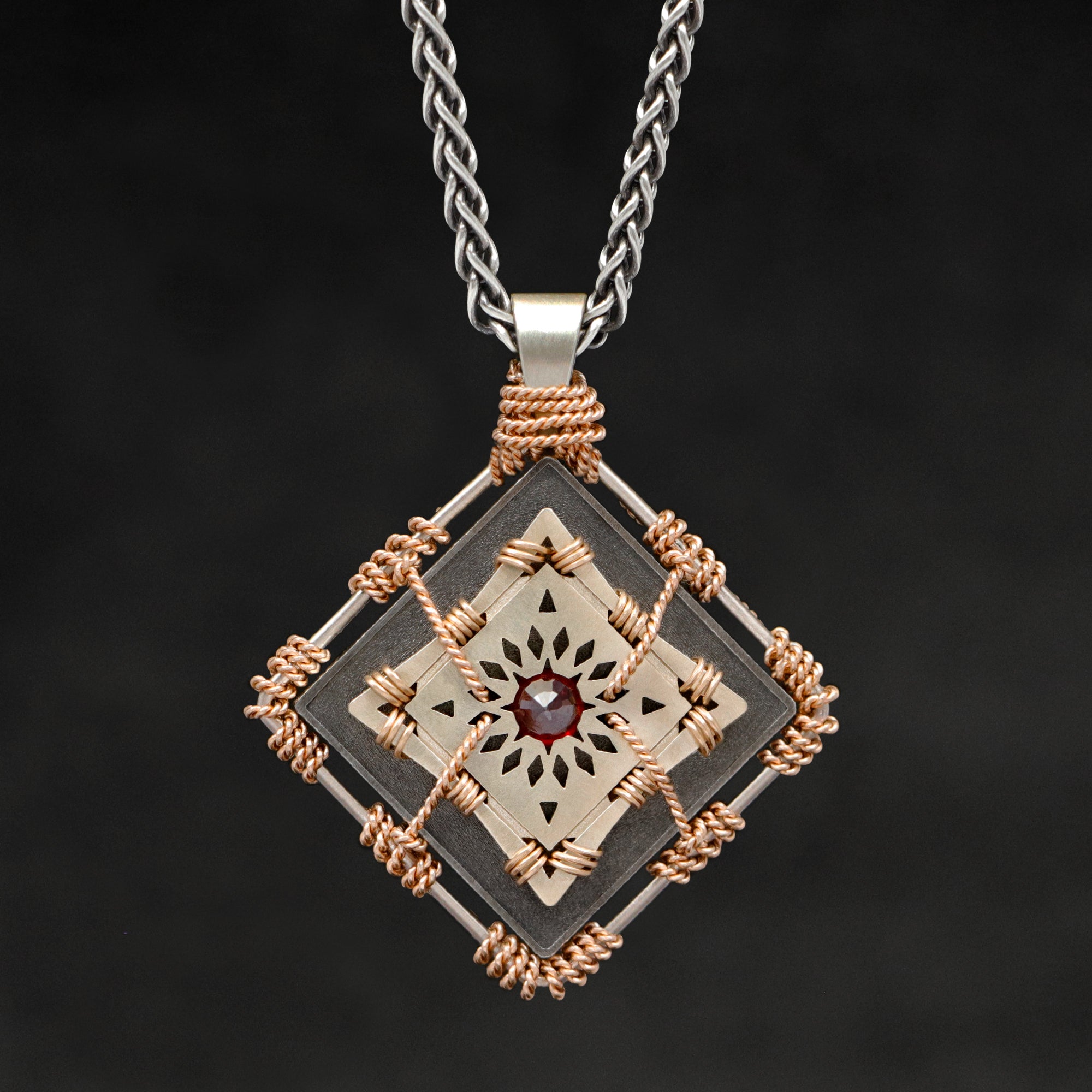 Hanging front view of 18K Rose Gold and 18K Palladium White Gold and Sterling Silver and Ruby Sewn Gold Metal Confidence pendant and chain with endless loop necklace featuring 4 pointed gear by Caps Brothers