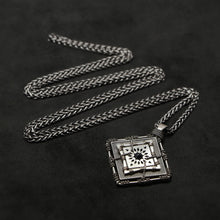 Load image into Gallery viewer, Laying down view of Sterling Silver and 18K Palladium White Gold Accents and Black Sapphire Sewn Silver Metal Confidence pendant and chain with endless loop necklace featuring 4 pointed gear by Caps Brothers
