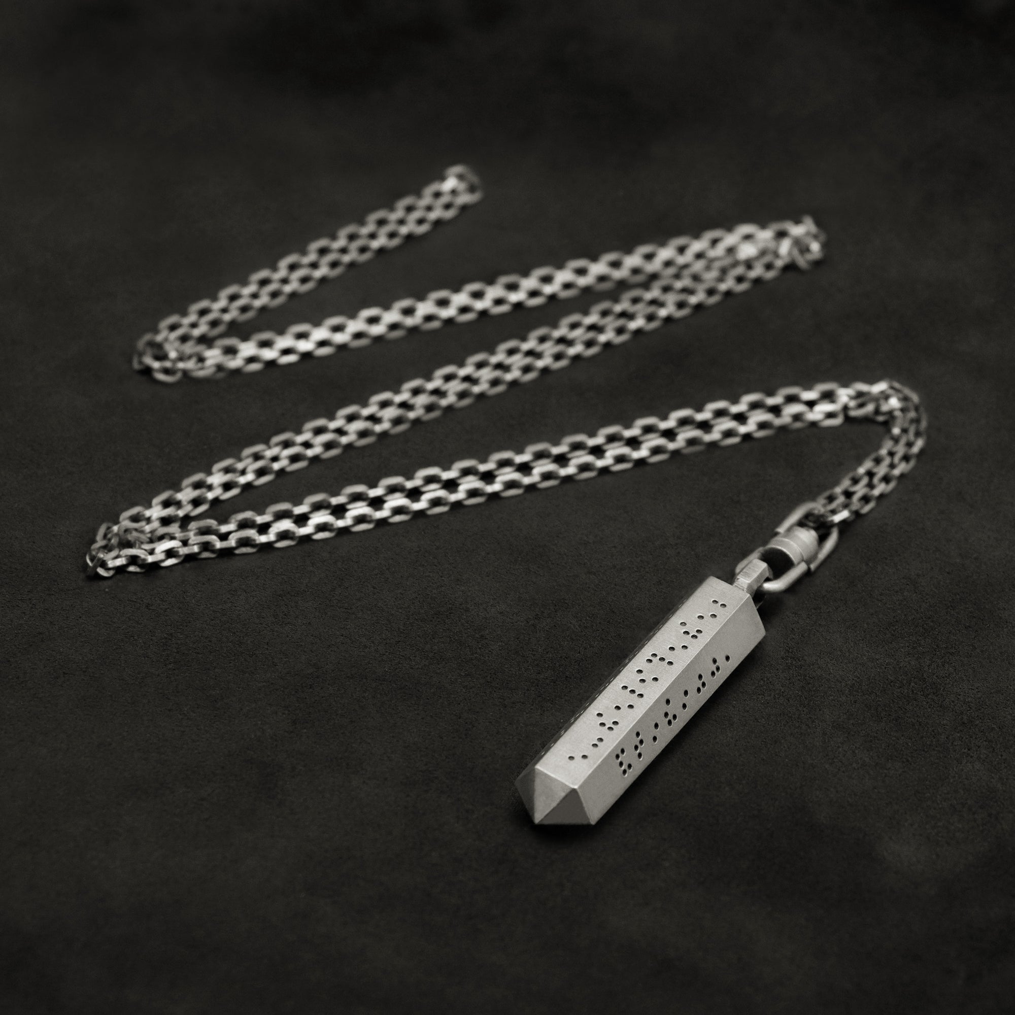 Laying down Code of Friendship hexagonal sterling silver pendant and chain with endless loop necklace featuring Inverted Braille by Caps Brothers