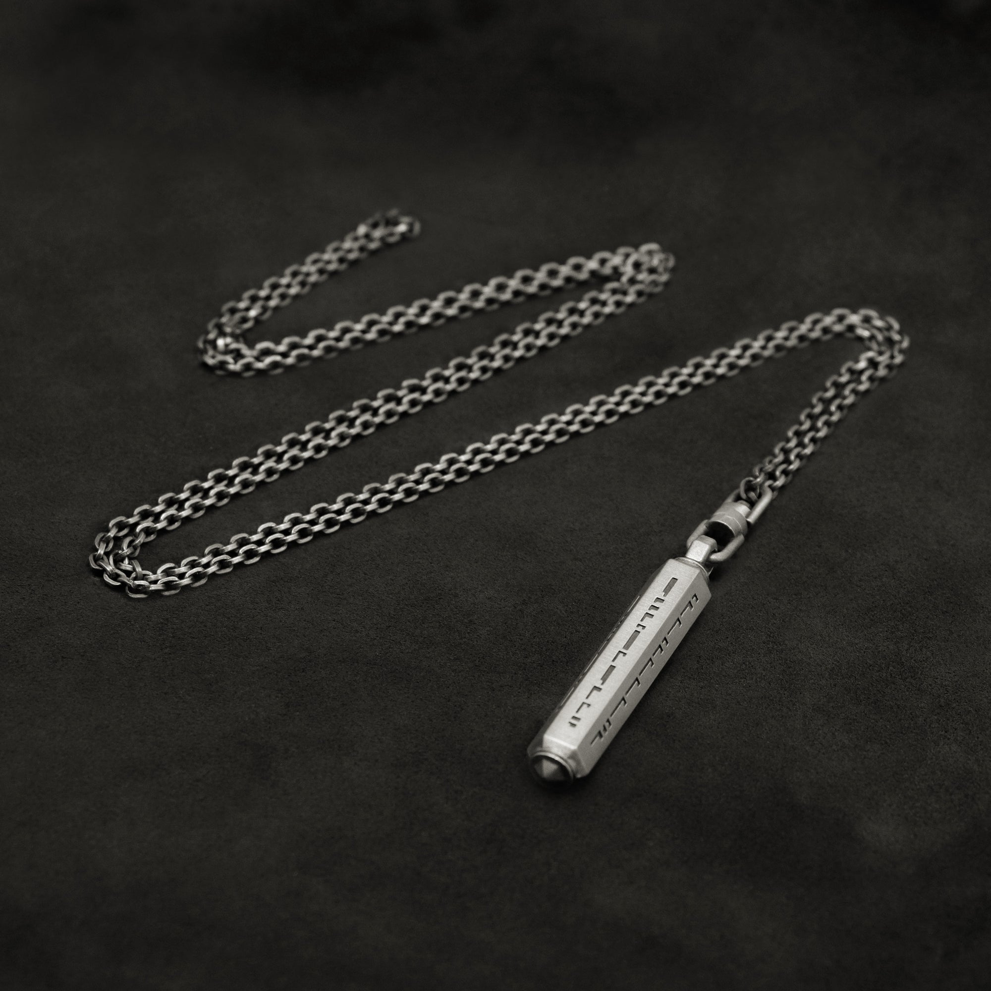 Laying down Code of Gratitude hexagonal sterling silver pendant and chain with endless loop necklace featuring ASCII Rays Code by Caps Brothers