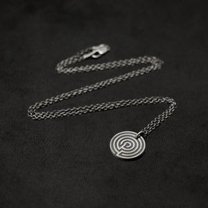 Laying down Sterling Silver Journey pendant and chain necklace with clasp featuring labyrinth as inward journey by Caps Brothers