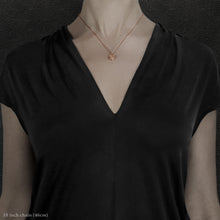 Load image into Gallery viewer, Model wearing 18K Rose Gold Journey pendant and chain necklace featuring the Map of Humanity as outward journey by Caps Brothers