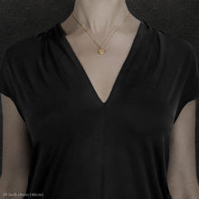 Load image into Gallery viewer, Model wearing 18K Yellow Gold Journey pendant and chain necklace featuring the Map of Humanity as outward journey by Caps Brothers