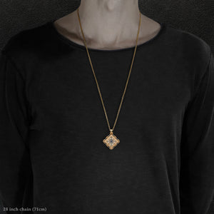 Model wearing 18K Yellow Gold and 18K Palladium White Gold and Sapphire Sewn Gold Metal Confidence pendant and chain with endless loop necklace featuring 4 pointed gear by Caps Brothers