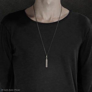 Model wearing Code of Gratitude hexagonal sterling silver pendant and chain with endless loop necklace featuring ASCII Rays Code by Caps Brothers