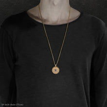 Load image into Gallery viewer, Model wearing 18K Yellow Gold and 18K Palladium White Gold and Sapphire Sewn Gold Metal Majesty pendant and chain with endless loop necklace featuring 20 pointed gear by Caps Brothers